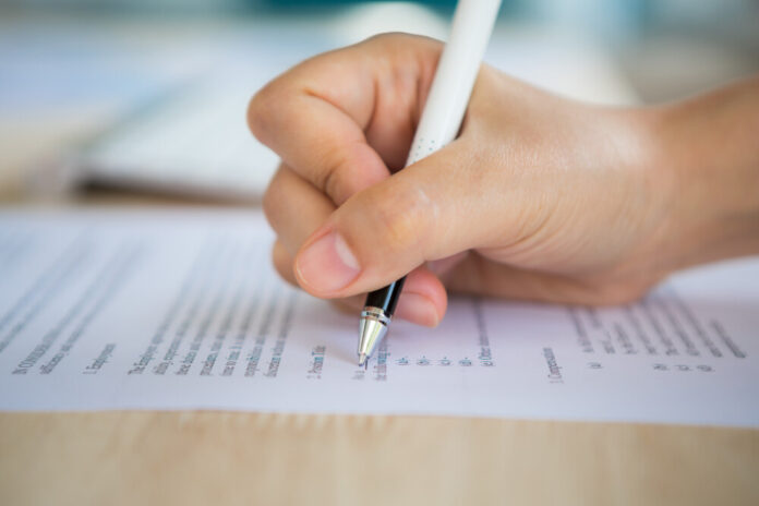 Close up of hand completing an employment application form concurso
